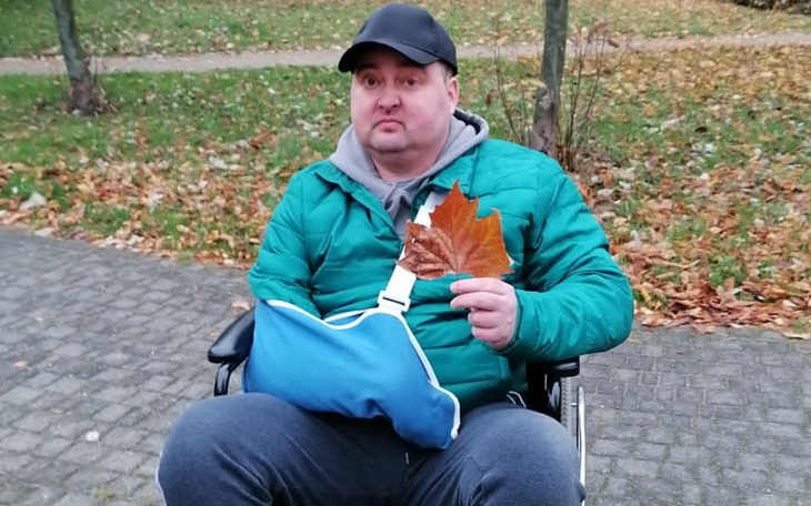 Mężczyzna w wózku inwalidzkim trzymający liść.