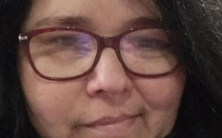 Kobieta w okularach, z uśmiechem na twarzy.