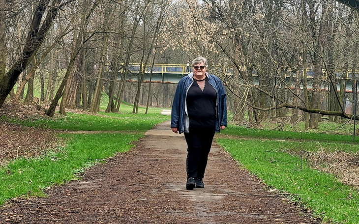 Kobieta spacerująca po parku w wiosennej scenerii.