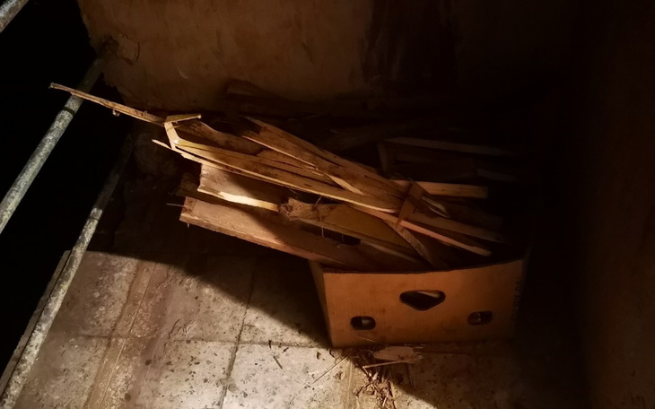 Stos drewnianych desek w kartonie na podłodze.