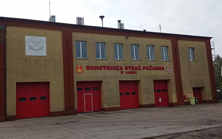 Budynek straży pożarnej z czerwonymi drzwiami.