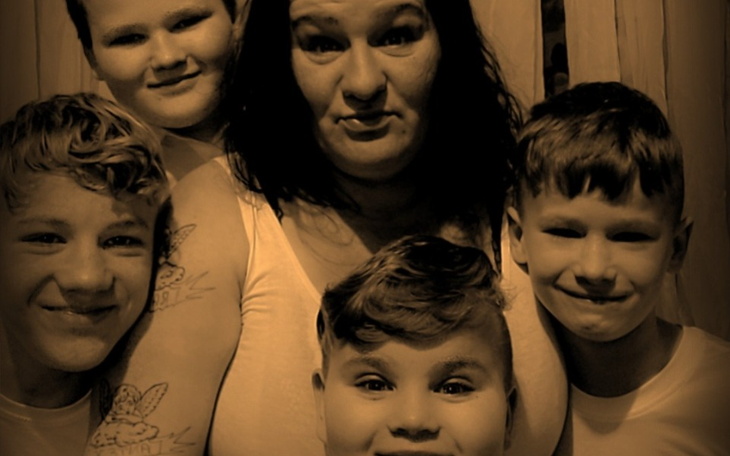 Rodzina pozująca do zdjęcia, uśmiechnięta i zadowolona.