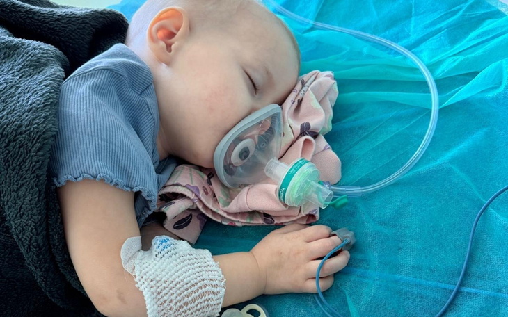 Małe dziecko śpiące z maską tlenową w szpitalu.