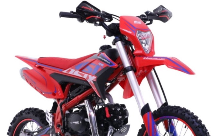 Czerwony motocykl terenowy na białym tle.