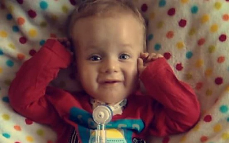 Mały chłopiec uśmiechający się na kolorowej kocyku.