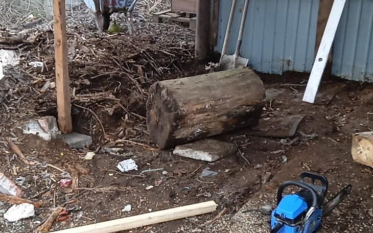 Ziemia z drewnem i narzędziami, w tle bałagan.