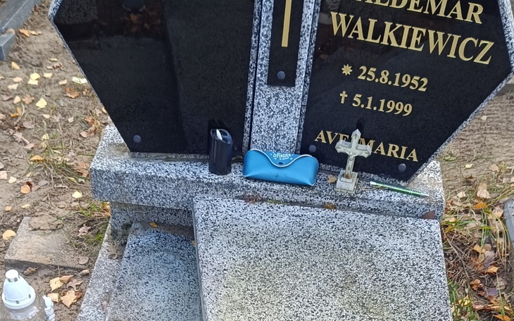 Grób z krzyżem i osobistymi przedmiotami.