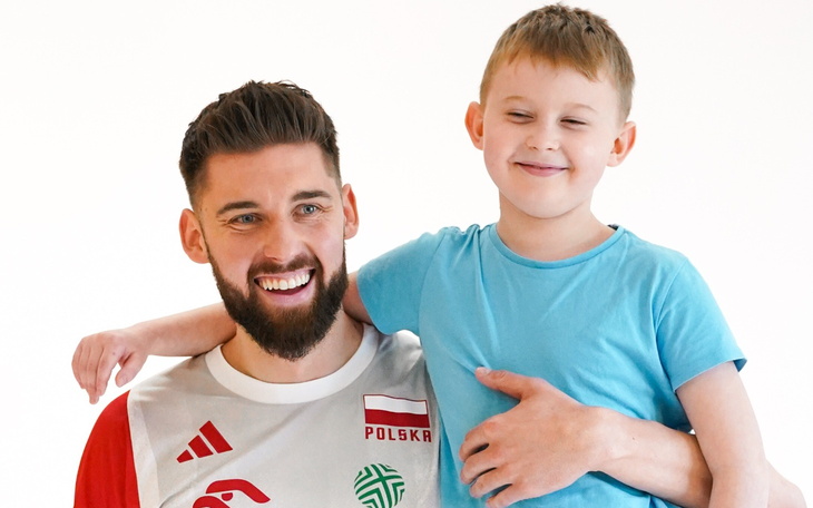 Uśmiechnięty mężczyzna z dzieckiem, oboje w radosnej chwili.