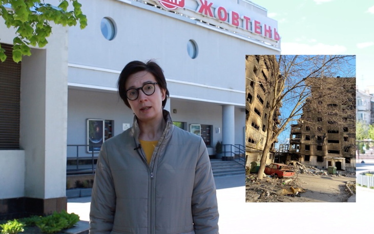 Dziennikarka przed zniszczonym budynkiem.