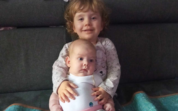 Dzieci siedzące razem na kanapie, uśmiechnięte i radosne.