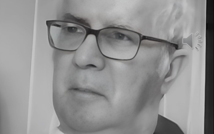 Mężczyzna w okularach, z poważnym wyrazem twarzy.