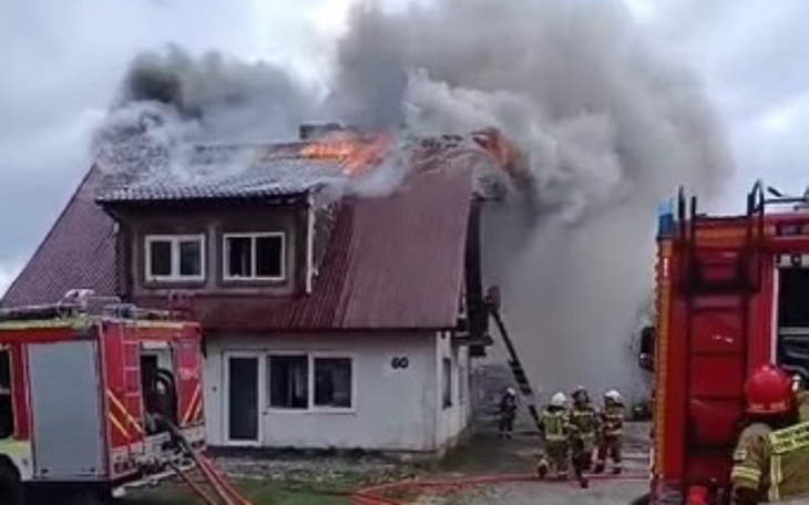 Pożar domu, strażacy walczą z ogniem.