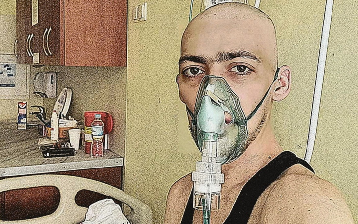 Mężczyzna w szpitalu z maską tlenową na twarzy.