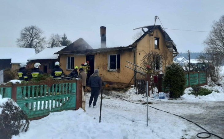 Pożar domu w zimowej scenerii, strażacy w akcji.