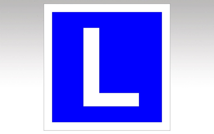 Znak drogowy z literą L, symbolizujący naukę jazdy.