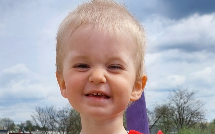 Mały chłopiec z szerokim uśmiechem, bawiący się na placu zabaw.