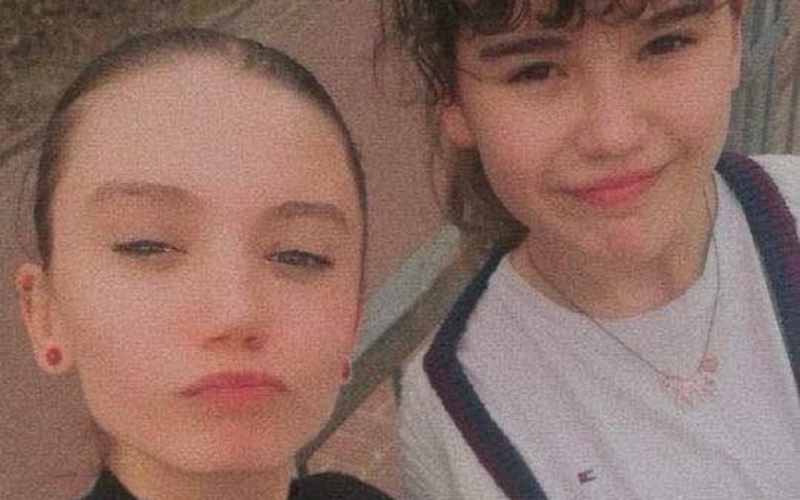 Dwie dziewczyny pozujące do zdjęcia na ulicy.