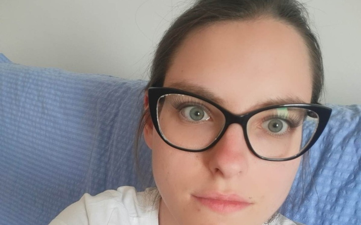 Młoda kobieta w okularach, patrząca w kamerę.