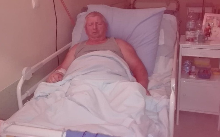 Mężczyzna leżący w szpitalnym łóżku, wygląda na zmęczonego.