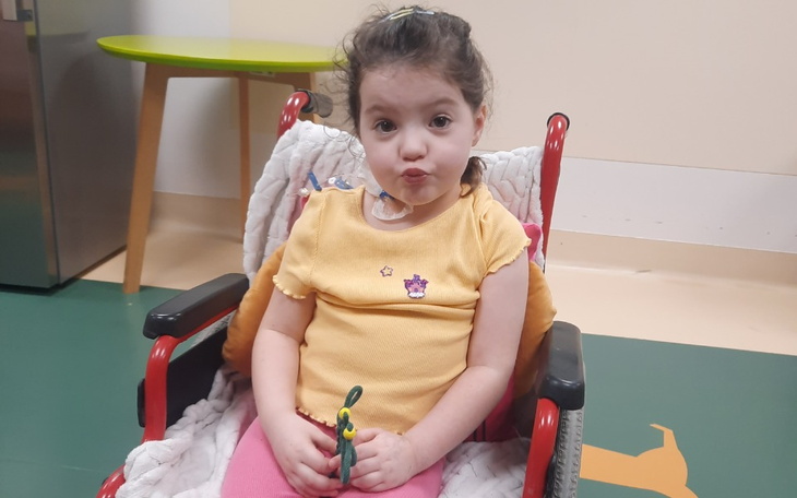 Mała dziewczynka w wózku, z uśmiechem na twarzy.