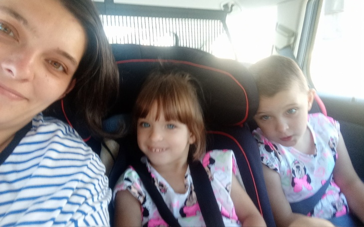 Kobieta z dwoma dziećmi w samochodzie.