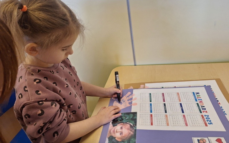 Dziewczynka rysująca na kalendarzu na 2025 rok.