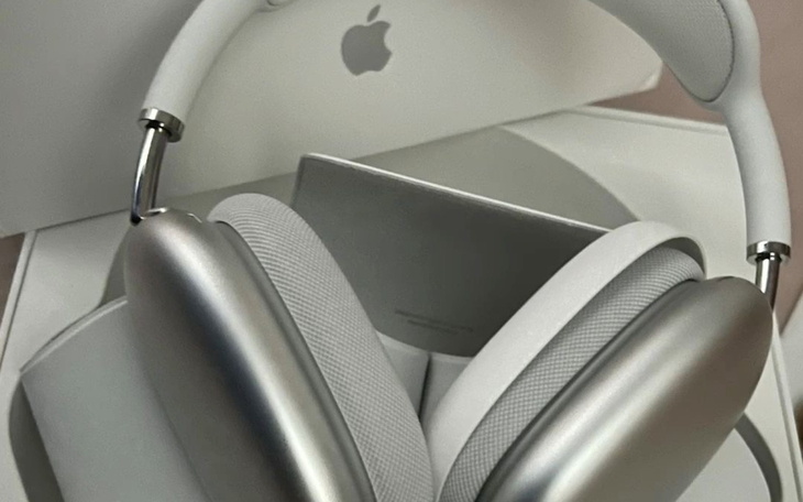 Słuchawki Apple leżą na stole obok pudełka.