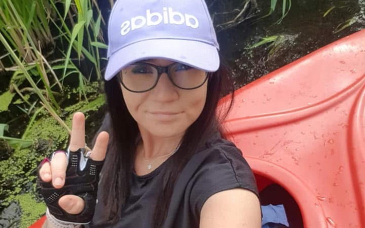 Kobieta w kajaku, pokazująca znak pokoju.