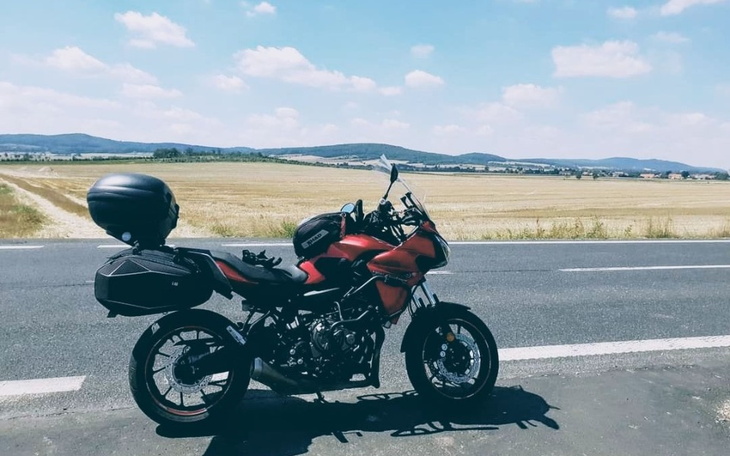 Motocykl na tle malowniczych pól, idealny na letnią przejażdżkę.