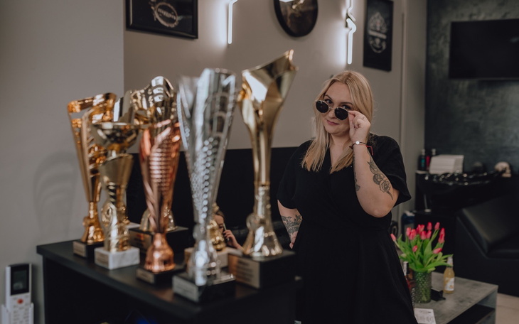 Kobieta w okularach przeciwsłonecznych przy trofeach w salonie.