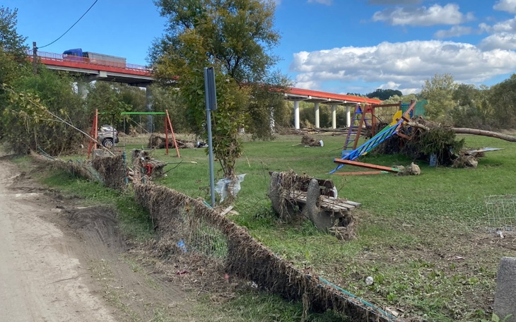 Zniszczony plac zabaw po powodzi, z widocznymi resztkami sprzętu.