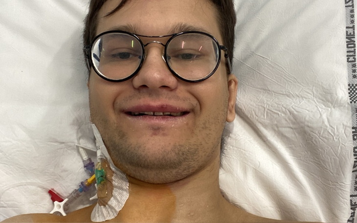 Młody mężczyzna w szpitalu, z uśmiechem na twarzy.