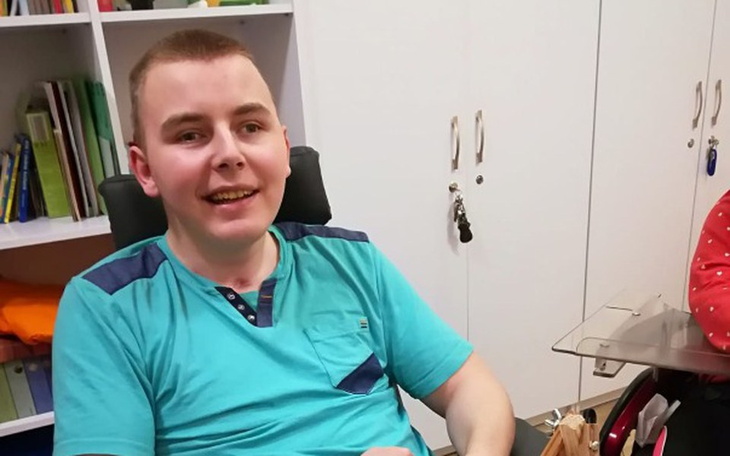 Młody mężczyzna uśmiechający się w biurze.