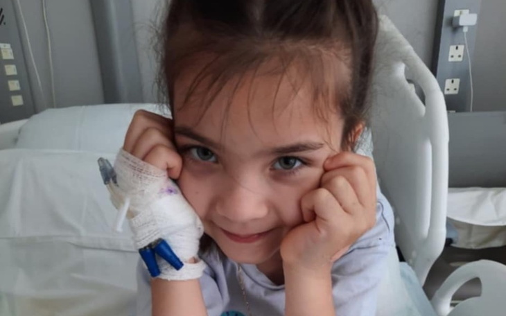 Mała dziewczynka w szpitalu z opatrunkiem na ręce.