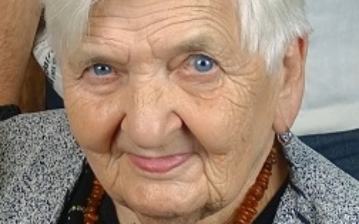 Portret starszej kobiety z niebieskimi oczami.