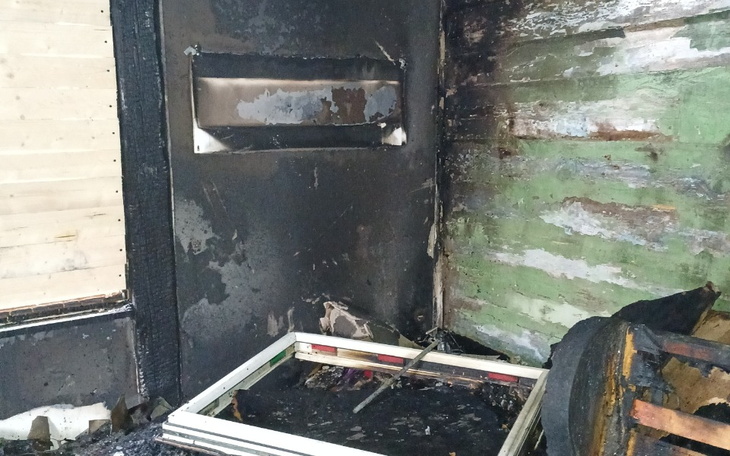 Zniszczona ściana po pożarze, z widocznymi śladami spalenizny.