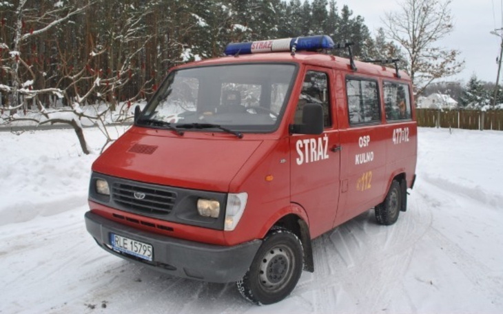 Czerwony wóz strażacki na tle zimowego krajobrazu.
