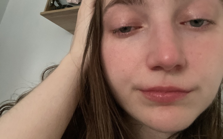 Młoda kobieta z wyraźnym smutkiem na twarzy.