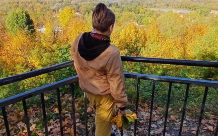 Osoba stojąca na tarasie widokowym, podziwiająca jesienne krajobrazy.