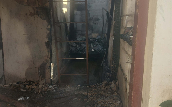 Zniszczone wejście z rozkruszoną podłogą i widoczną drabiną.