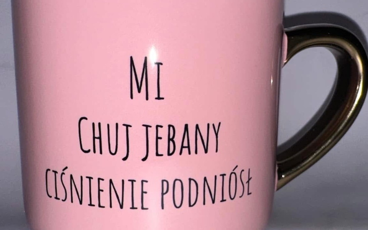 Różowy kubek z kontrowersyjnym napisem, humorystyczny dodatek.