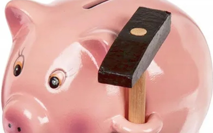 Skarbonka w kształcie świnki z młotkiem obok.