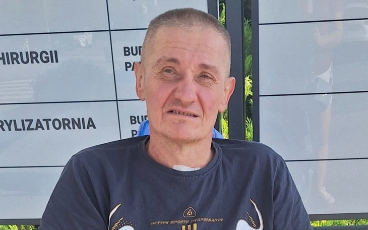 Mężczyzna siedzący na ławce, z wyrazem twarzy pełnym refleksji.