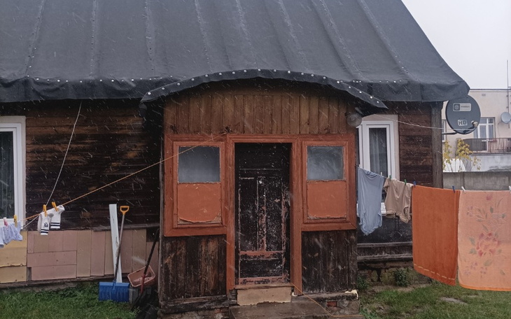 Stary dom z praniem rozwieszonym na zewnątrz.