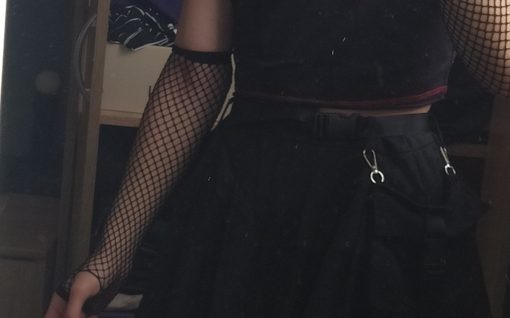 Stylizacja z siateczkowymi rękawami i czarną spódnicą.