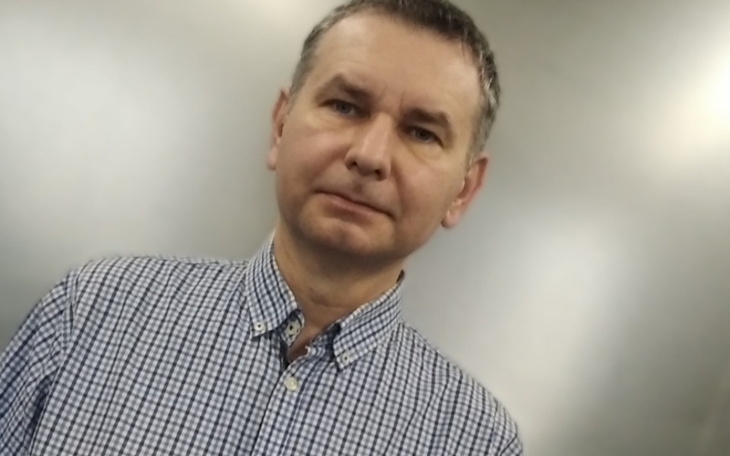 Mężczyzna w koszuli w kratę, patrzący w obiektyw.