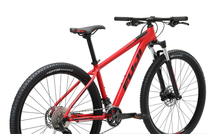 Czerwony rower górski z nowoczesnym osprzętem na białym tle.