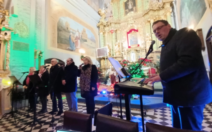 Występ artystyczny w kościele, z kolorowymi światłami i muzykami.