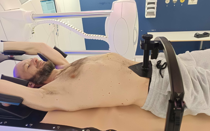 Mężczyzna leżący na aparacie medycznym, w trakcie terapii.