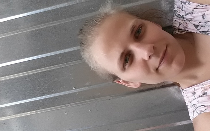 Portret kobiety na tle metalowej powierzchni.